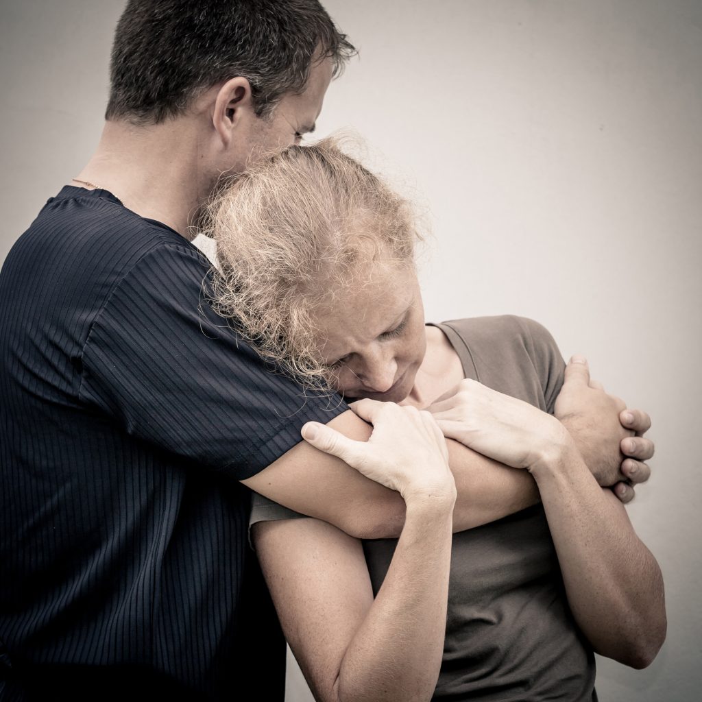Femme en détresse réconfortée dans les bras d’un homme, scène d’empathie, de soutien émotionnel et de compassion